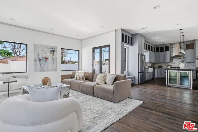 a kitchen with stainless steel appliances granite countertop a stove top oven a sink a dining table and chairs