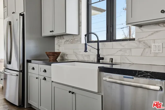 a kitchen with granite countertop white cabinets and stainless steel appliances