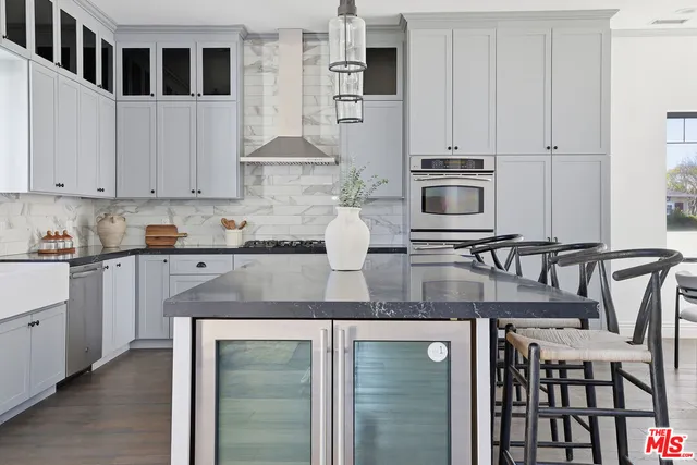 a kitchen with stainless steel appliances granite countertop a stove and a wooden floors
