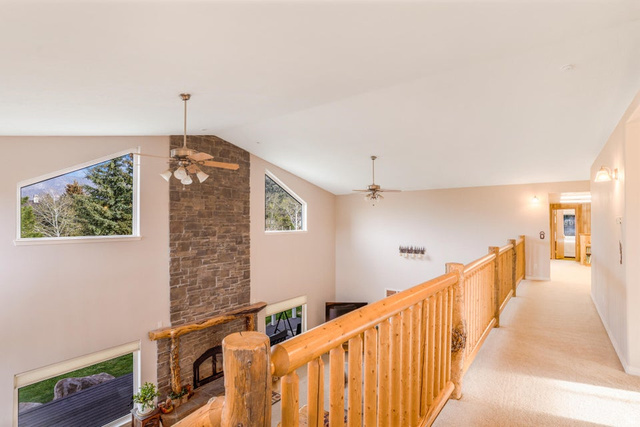 48 South Sage Road Pine Valley, UT 84781 - Photo 40 of 61 Expansive great room featuring a floor-to-ceiling stone fireplace with a log mantel, vaulted ceilings, and a wood-finish railing