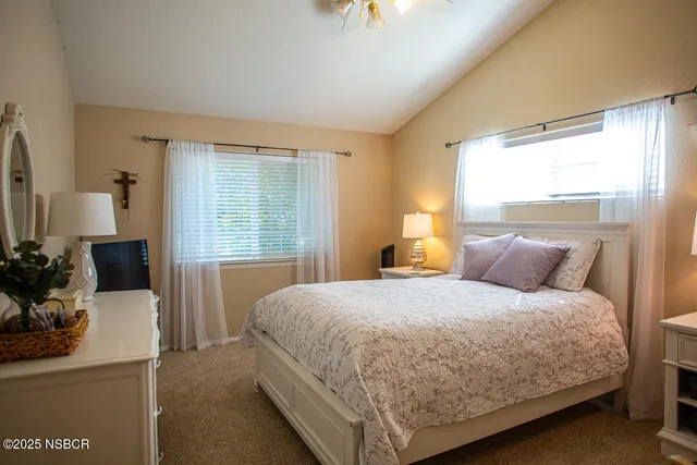 a bedroom with a bed tables and window