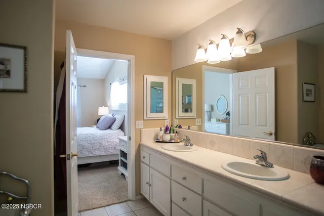 a en suite bathroom with a double vanity sink and a mirror