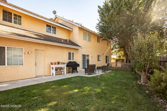 a view of a house with backyard and sitting area