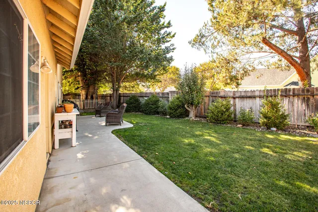 a view of a patio with table and chairs next to a yard