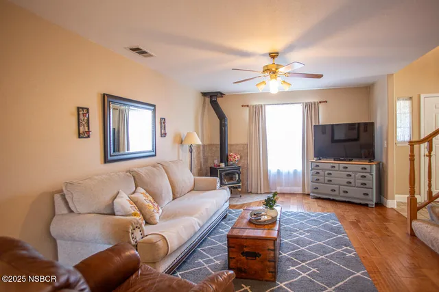 a living room with furniture a flat screen tv and a chandelier