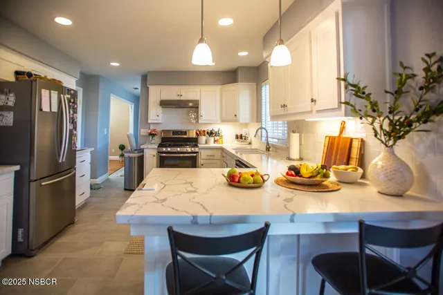 a kitchen with refrigerator and chairs