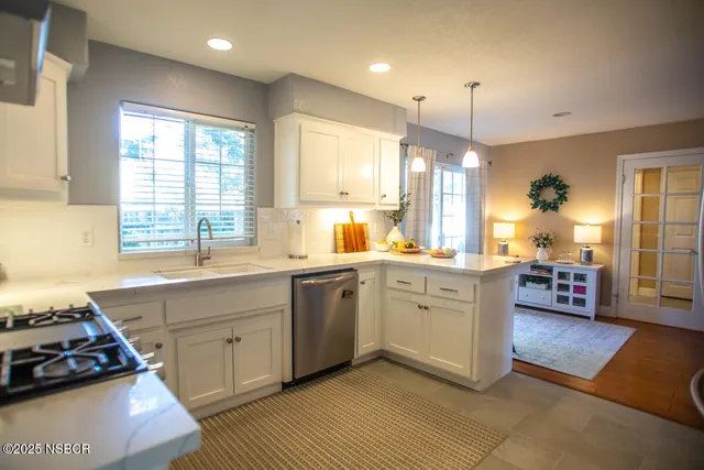 a kitchen with a sink stove and wooden floor