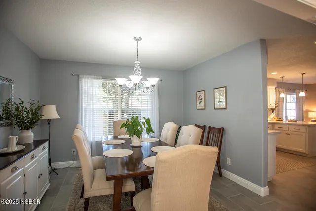 a dining room with furniture a chandelier and window