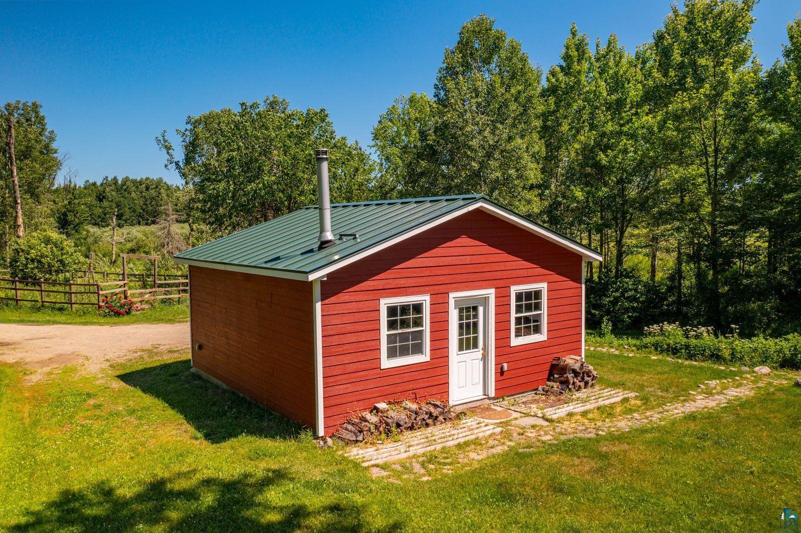 9734 Alango Road Angora, MN 55703 - Photo 18 of 41 Red siding exterior with a green metal roof