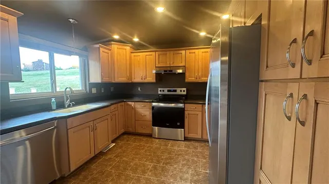 a kitchen with stainless steel appliances granite countertop a refrigerator and a sink