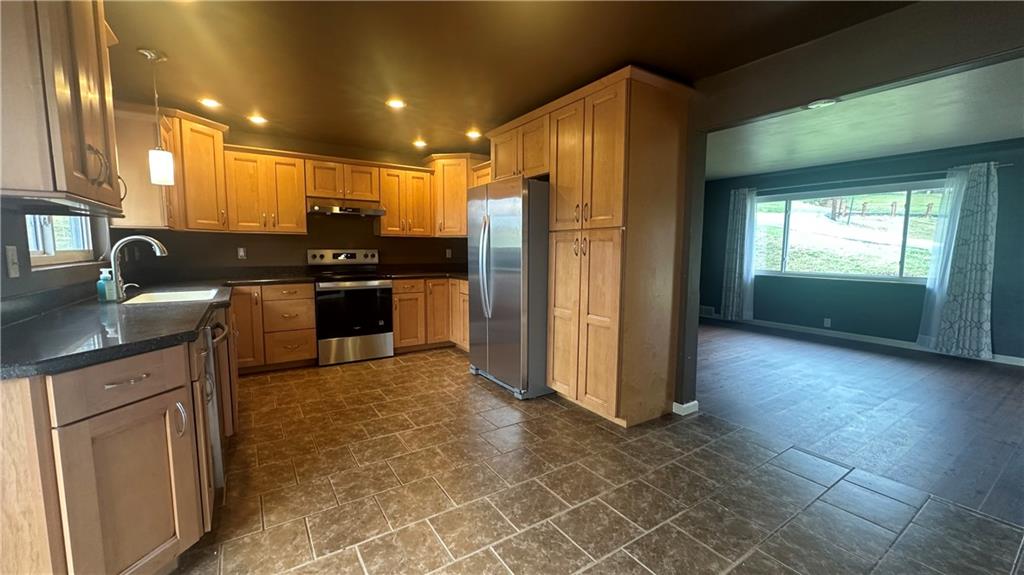 225 Larson Boulevard Rostraver Township, PA 15012 - Photo 14 of 46 a kitchen with stainless steel appliances granite countertop a refrigerator a sink a stove and island