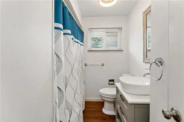 a white toilet sitting next to a bathroom sink and a mirror