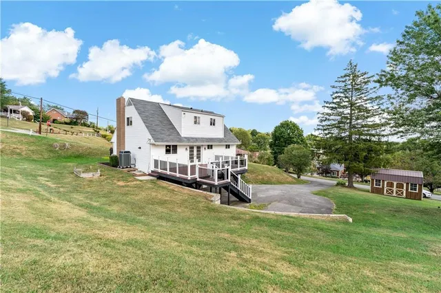 a view of a house with big yard and sitting area