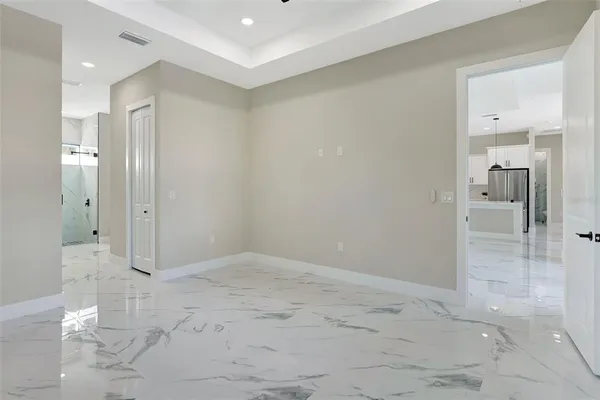 an empty room with windows and ceiling fan