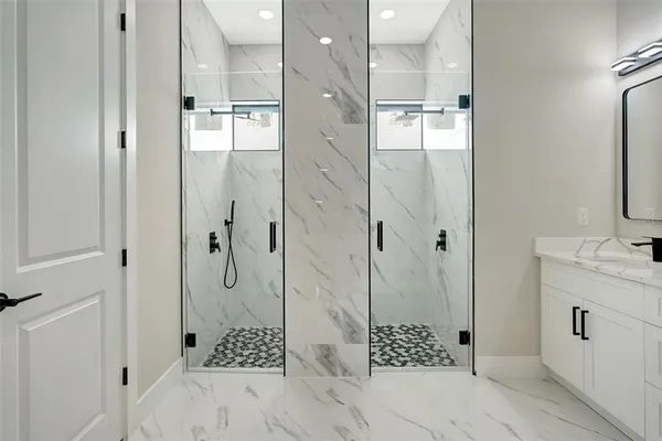 an empty room with a chandelier fan and windows