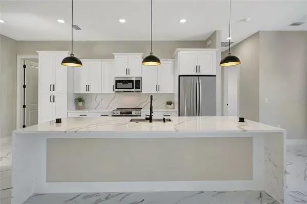 a kitchen with stainless steel appliances a refrigerator sink and microwave