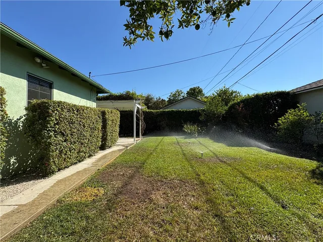 a view of backyard of house with green space