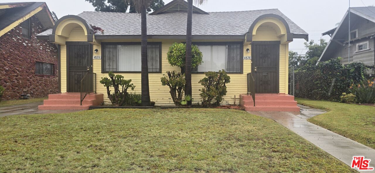 a view of a house with many windows and a yard