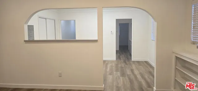 a view of a room with wooden floor and mirror