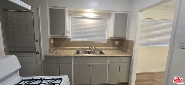 a bathroom with a granite countertop sink a toilet and shower