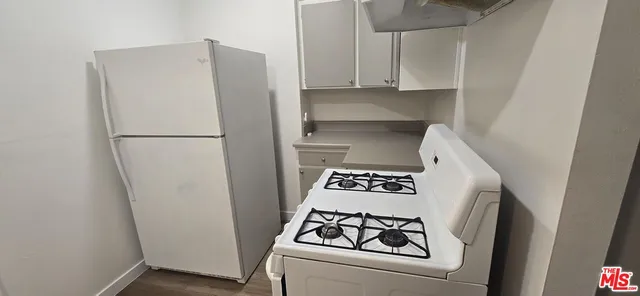 a white refrigerator freezer and a stove sitting inside of a kitchen