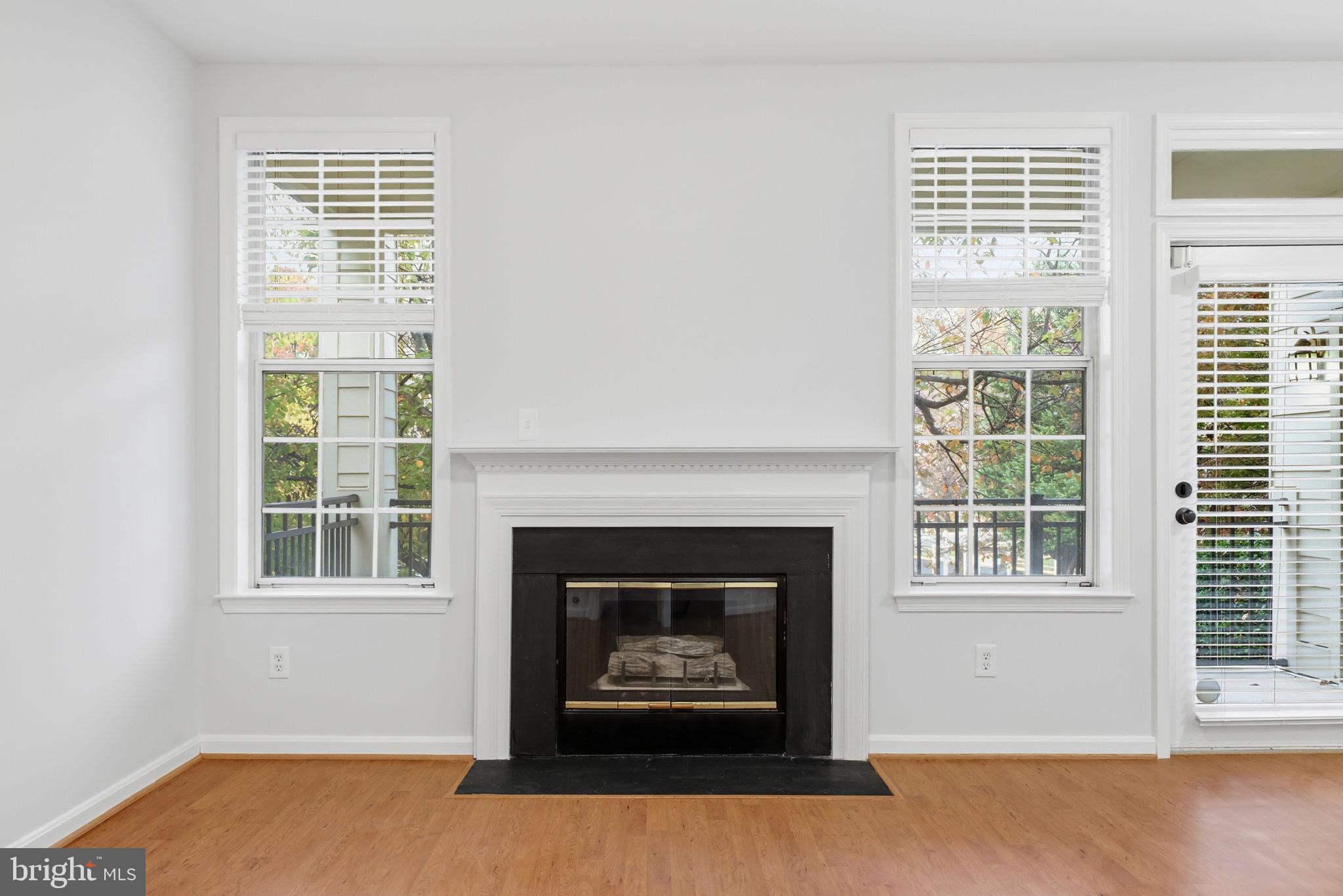 1340 Garden Wall Circle, Unit 502 Reston, VA 20194 - Photo 11 of 32 a living room with a fireplace and windows