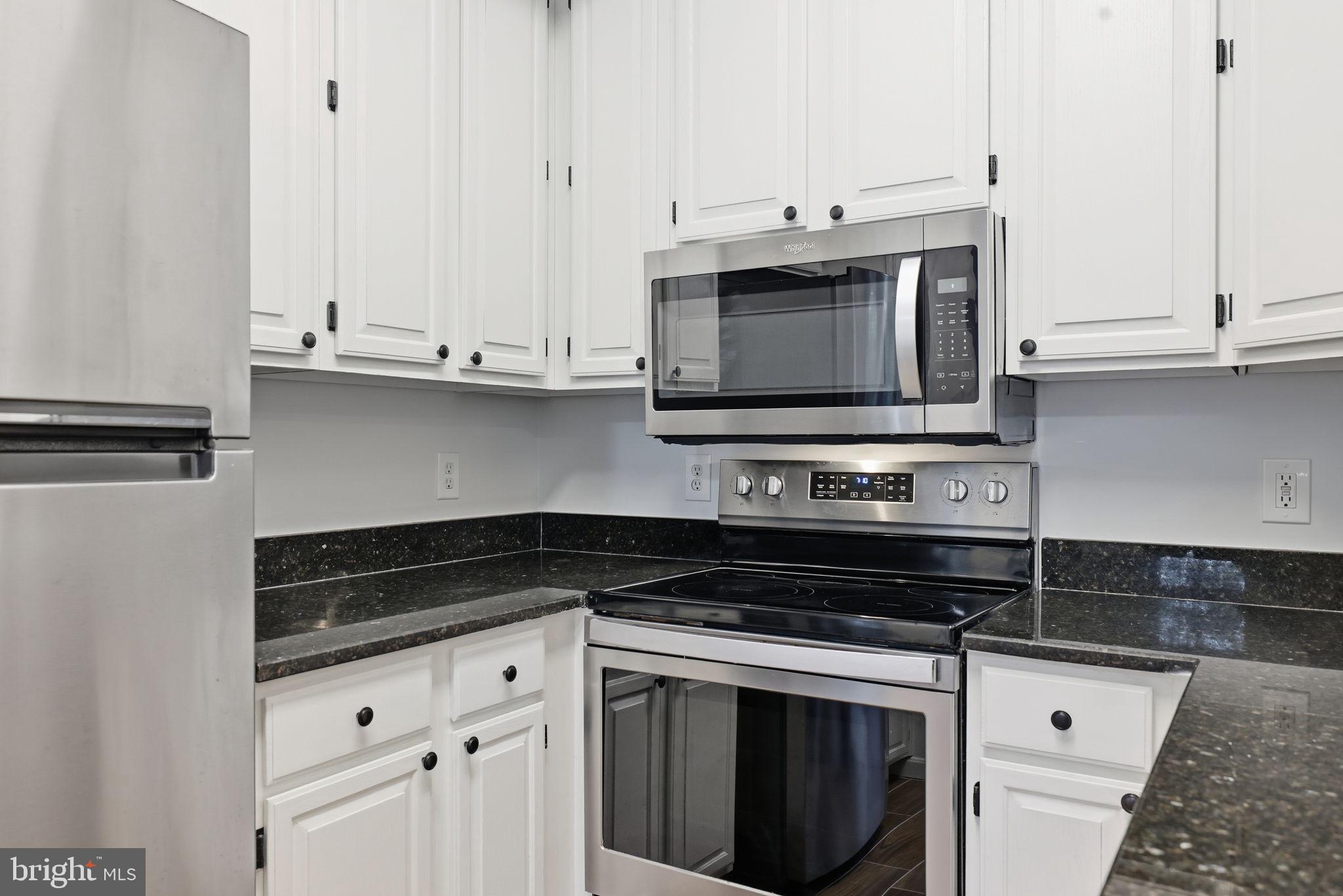 1340 Garden Wall Circle, Unit 502 Reston, VA 20194 - Photo 16 of 32 a kitchen with granite countertop white cabinets and stainless steel appliances