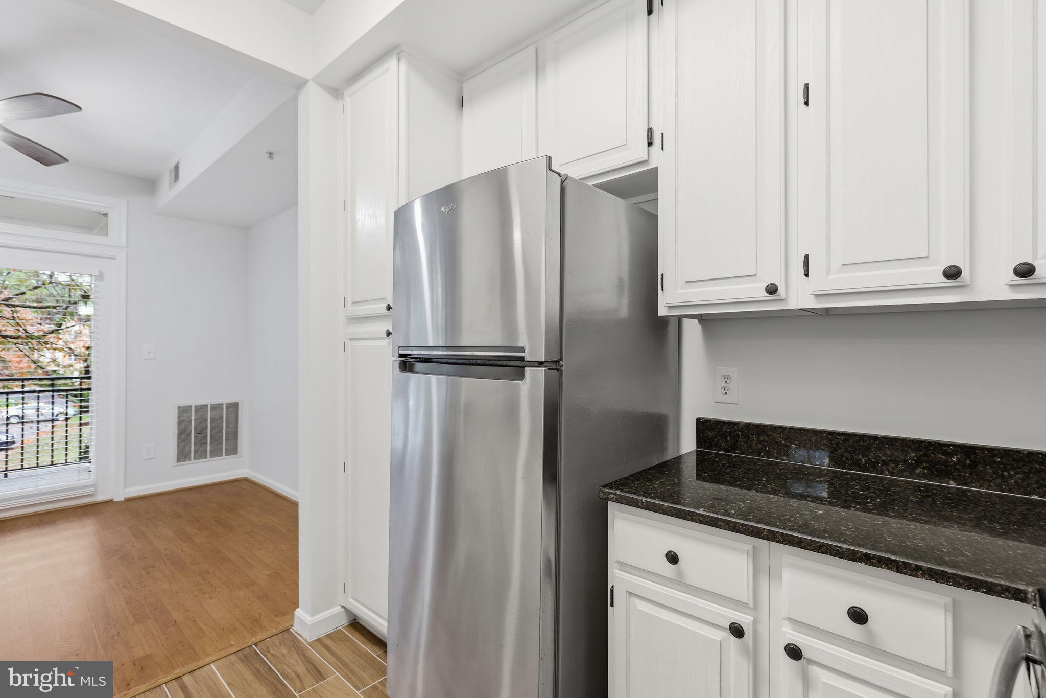 1340 Garden Wall Circle, Unit 502 Reston, VA 20194 - Photo 17 of 32 a kitchen with granite countertop white cabinets and refrigerator