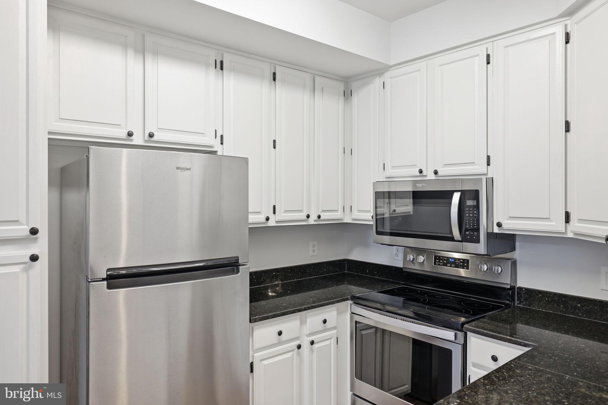 1340 Garden Wall Circle, Unit 502 Reston, VA 20194 - Photo 19 of 32 a kitchen with white cabinets and stainless steel appliances