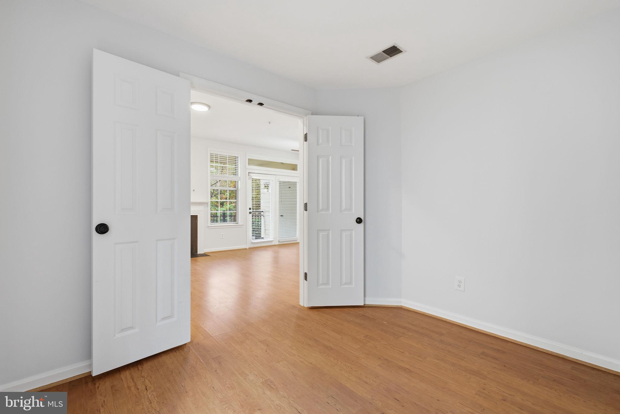 1340 Garden Wall Circle, Unit 502 Reston, VA 20194 - Photo 9 of 32 an empty room with wooden floor and windows
