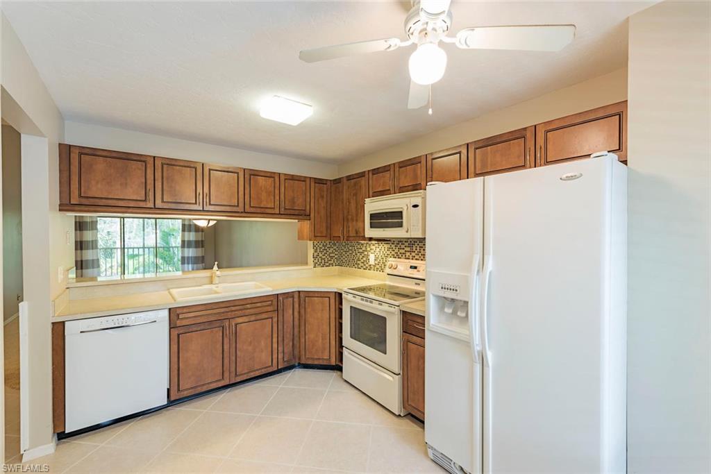 3451 County Barn Road, Unit G204 Naples, FL 34112 - Photo 5 of 12 a kitchen with stainless steel appliances a refrigerator sink and cabinets