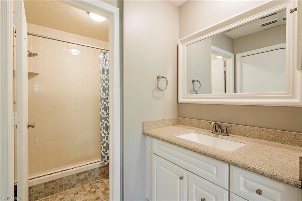 3451 County Barn Road, Unit G204 Naples, FL 34112 - Photo 7 of 12 a bathroom with a granite countertop sink mirror and double