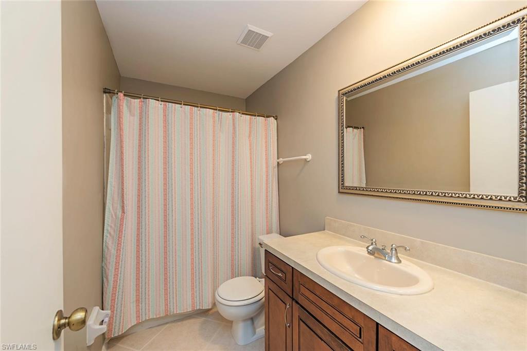 3451 County Barn Road, Unit G204 Naples, FL 34112 - Photo 9 of 12 a bathroom with a sink a toilet and a mirror