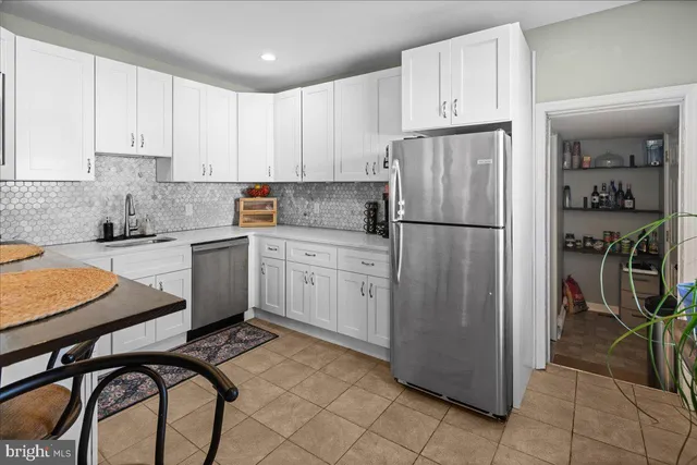 a kitchen with a refrigerator a sink and cabinets
