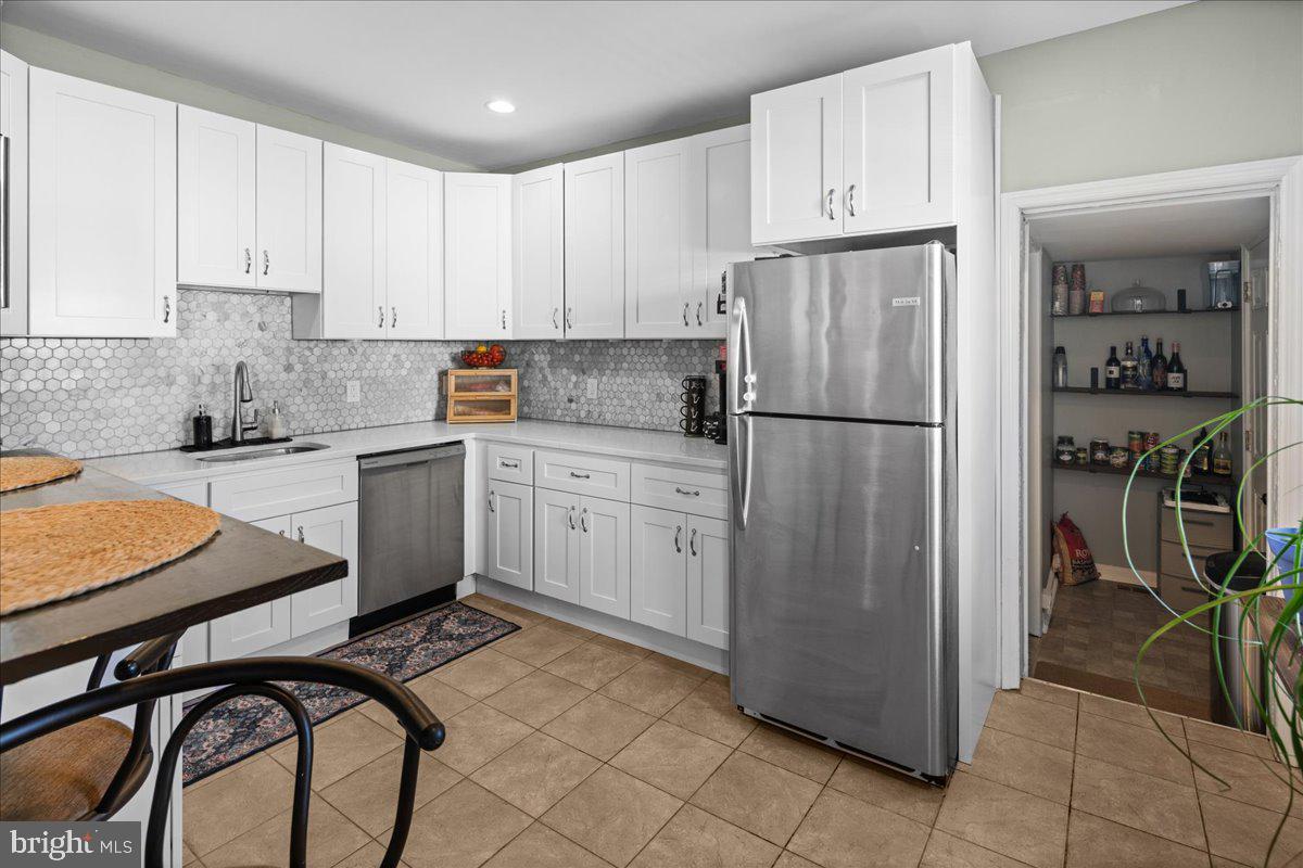 48 Homestead Avenue Ewing, NJ 08638 - Photo 6 of 21 a kitchen with a refrigerator a sink and cabinets
