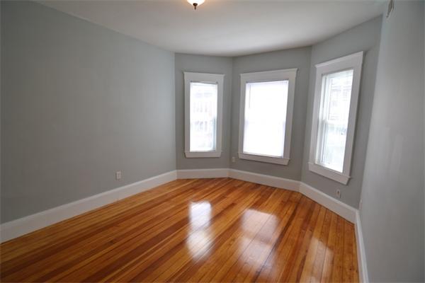 104 King Street, Unit 2 Boston, MA 02122 - Photo 5 of 29 a view of an empty room with wooden floor and a window