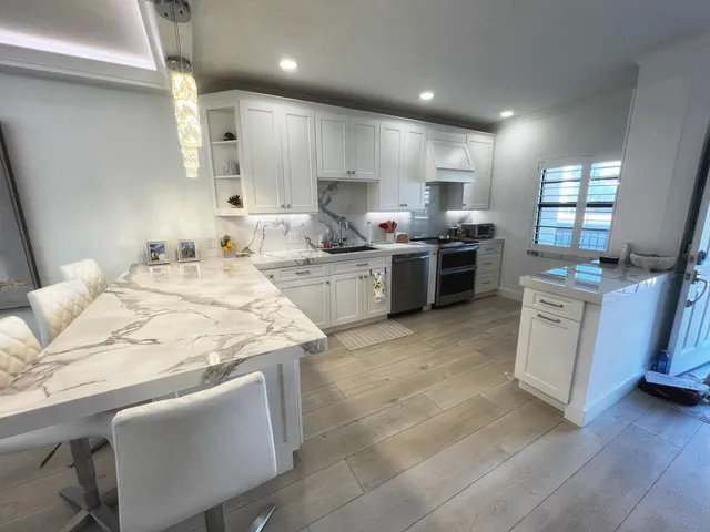 a kitchen with stainless steel appliances kitchen island granite countertop a sink and cabinets