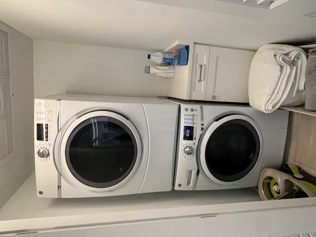 a utility room with dryer washer and a view of kitchen