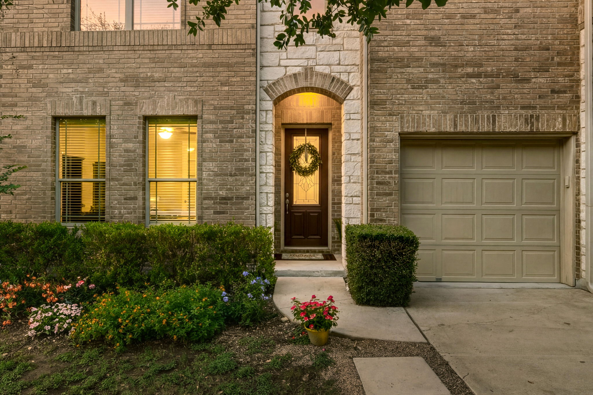 110 Dasher Drive Cedar Park, TX 78613 - Photo 2 of 39 An inviting facade featuring a decorative arched entry, brick and stone construction, and an attached garage.