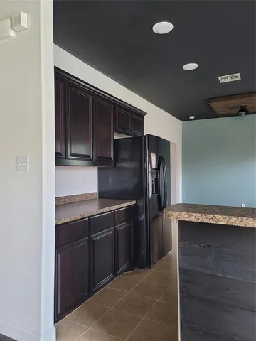 a kitchen with granite countertop cabinets and refrigerator