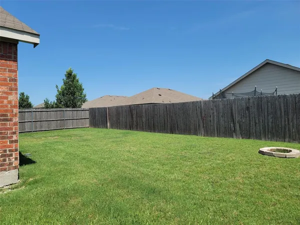 a view of a backyard with wooden fence