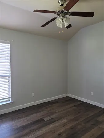 a view of a room with wooden floor and ceiling fan