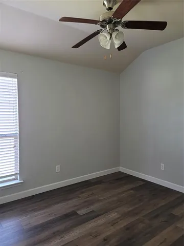 a view of a room with wooden floor and ceiling fan