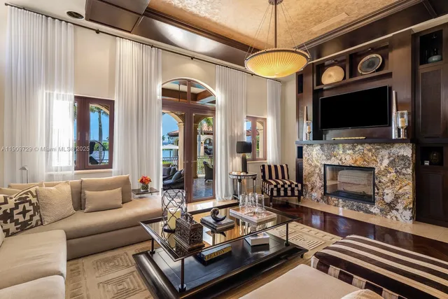 a living room with furniture a flat screen tv and a fireplace