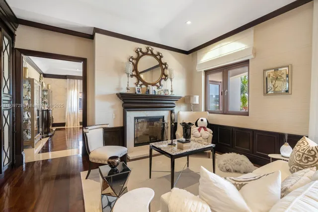a living room with furniture a flat screen tv and floor to ceiling window
