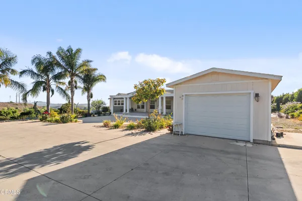 front view of a house with a yard and a car parked
