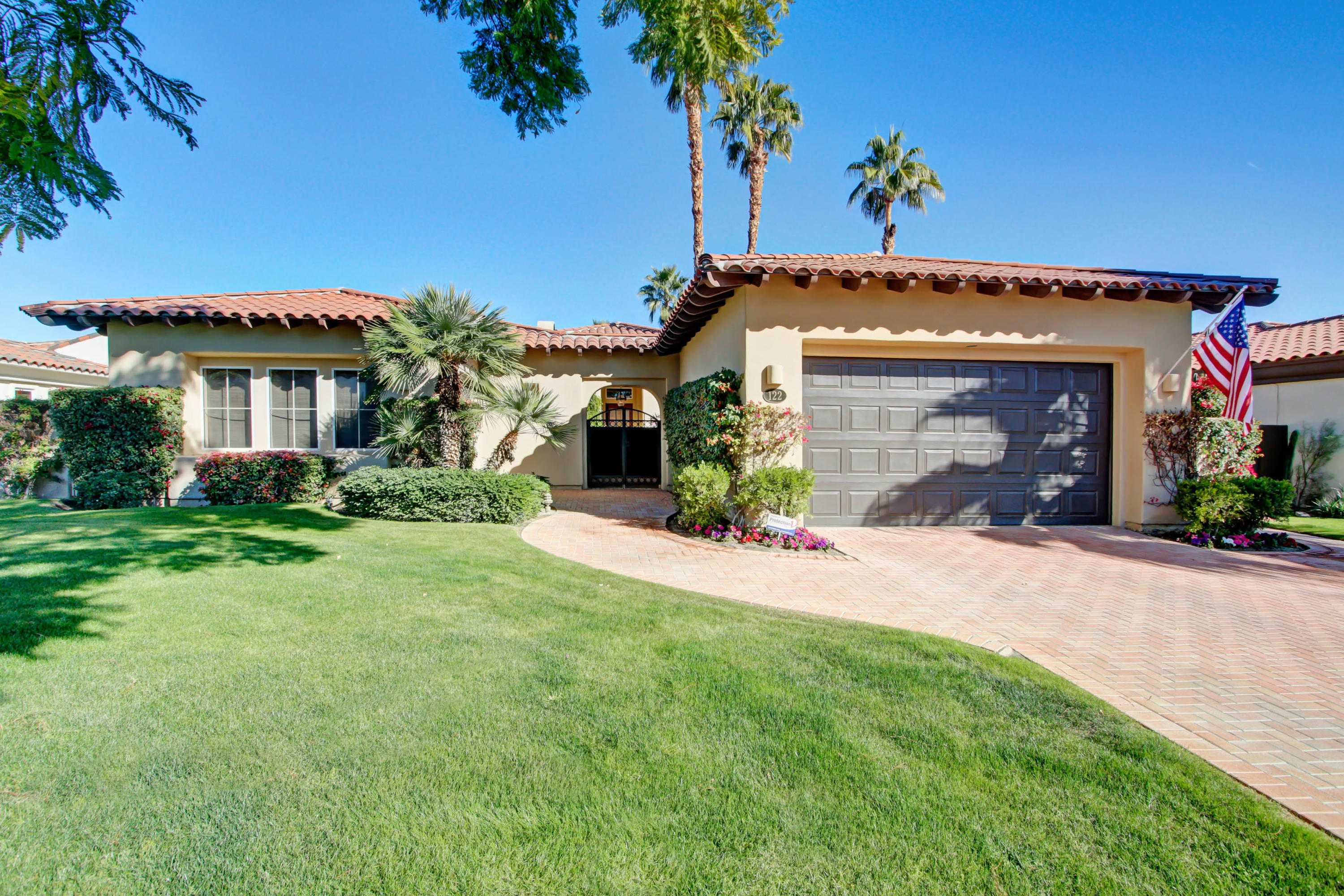 122 Loch Lomond Road Rancho Mirage, CA 92270 - Photo 2 of 34 a front view of a house with a yard and garage