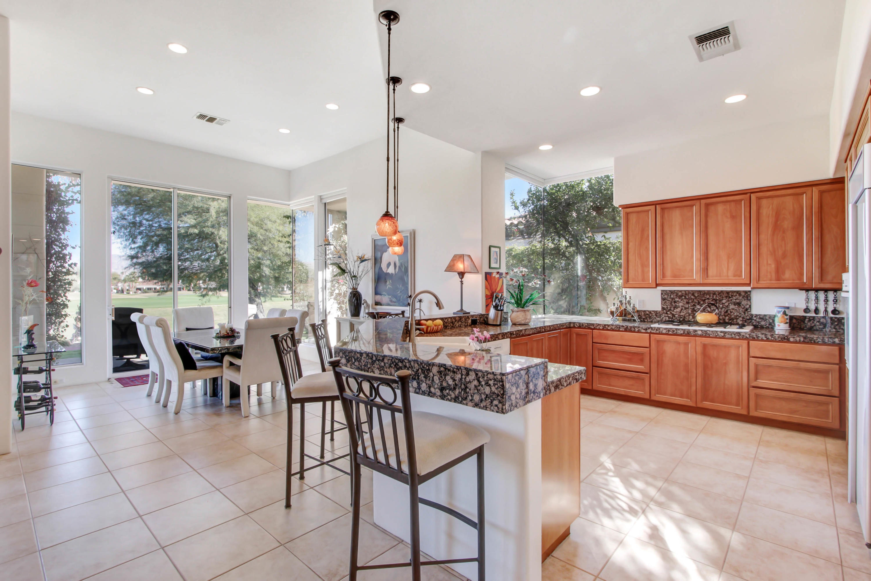 122 Loch Lomond Road Rancho Mirage, CA 92270 - Photo 11 of 34 a kitchen with stainless steel appliances granite countertop table chairs stove and cabinets
