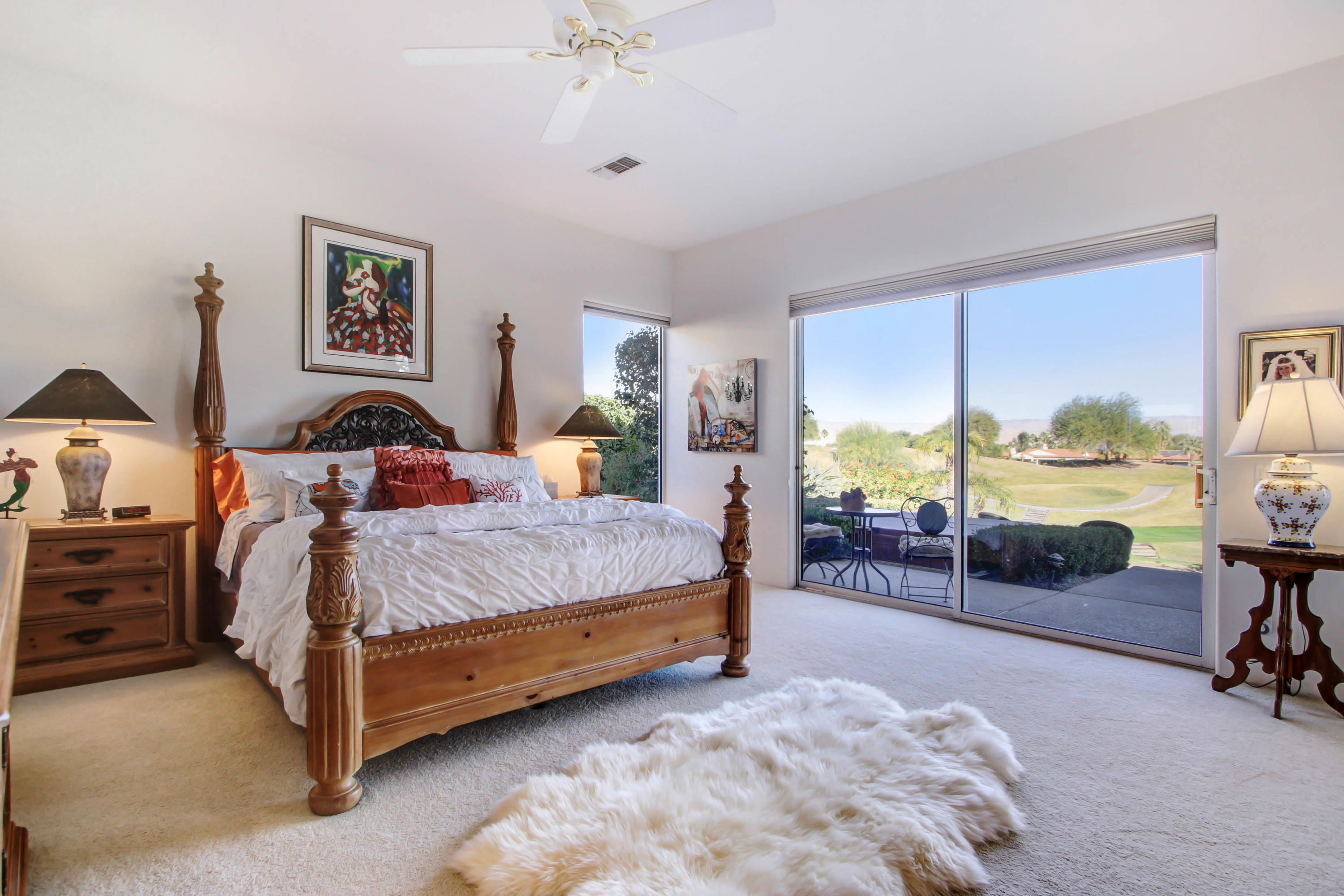 122 Loch Lomond Road Rancho Mirage, CA 92270 - Photo 15 of 34 a spacious bedroom with a bed a table and painting on the wall