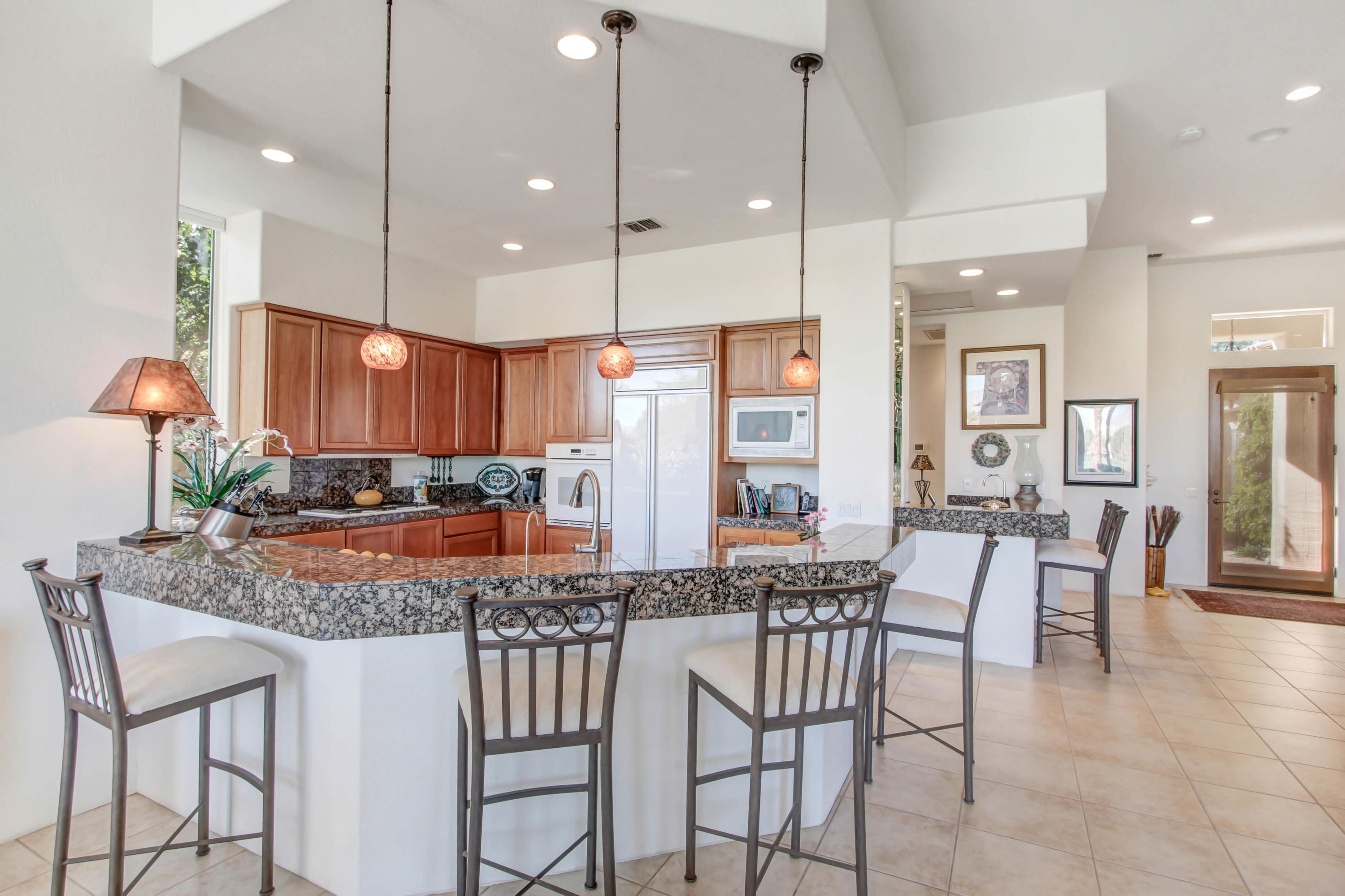 122 Loch Lomond Road Rancho Mirage, CA 92270 - Photo 10 of 34 a kitchen with stainless steel appliances granite countertop wooden floor window and chairs